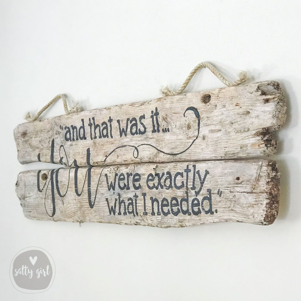 A wooden sign with a message written on it, hanging on a wall.