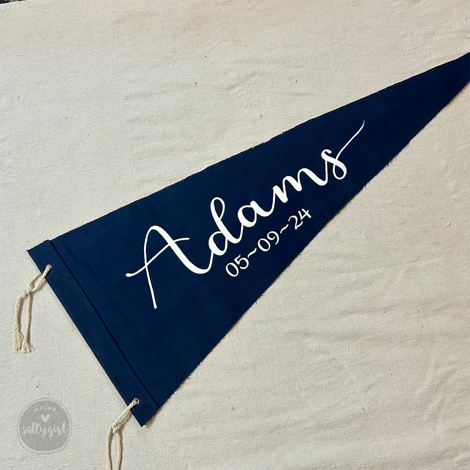 Navy blue pennant with white text on a textured surface