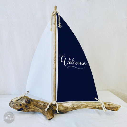 a small sailboat with a welcome sign on it