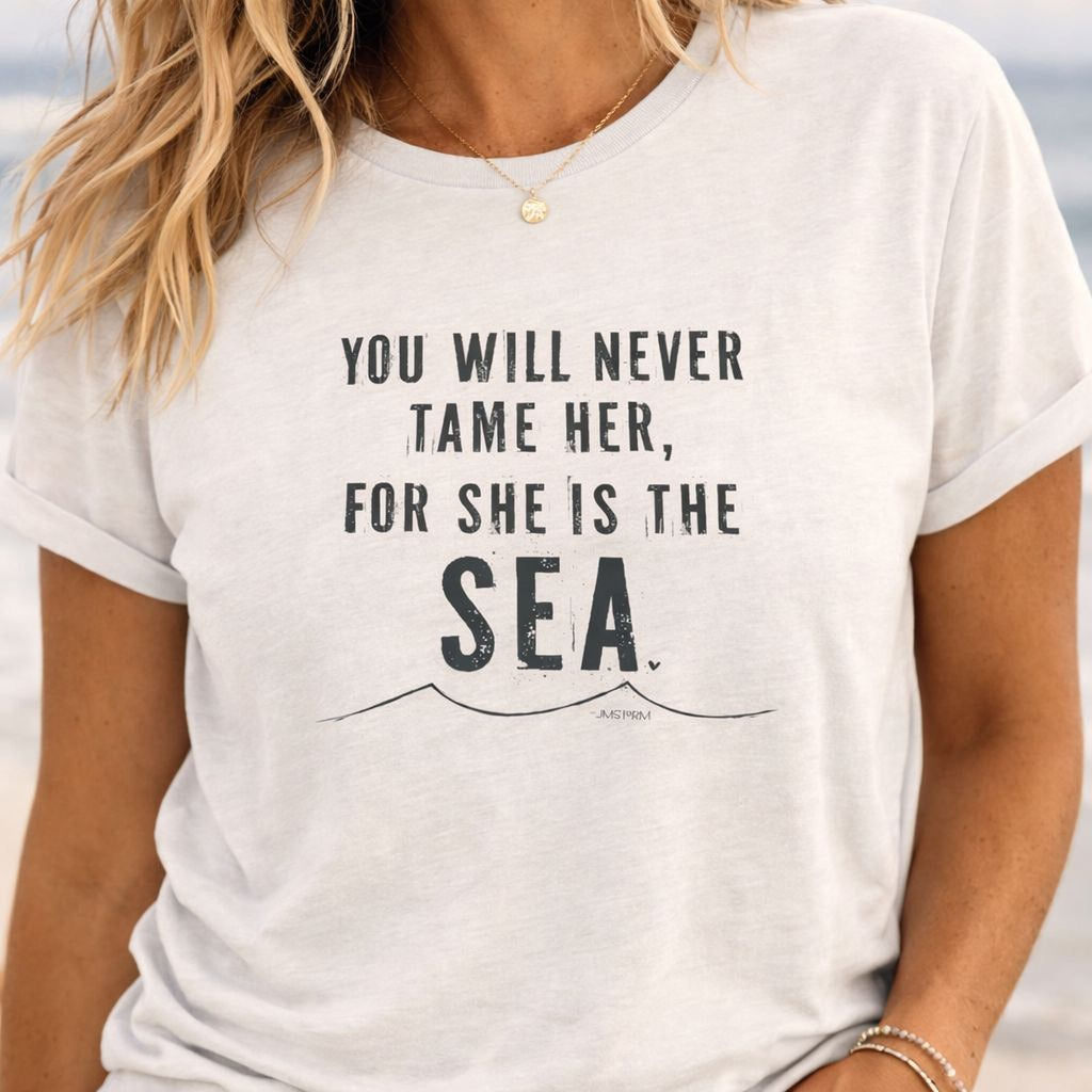 A white t-shirt with the text "YOU WILL NEVER TAME HER, FOR SHE IS THE SEA" printed on it.