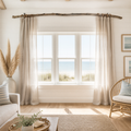 a serene living room with a large window overlooking the ocean, featuring a view of the beach. The room is decorated with a wicker chair, a rug, and a potted plant, creating a cozy and inviting atmosphere.