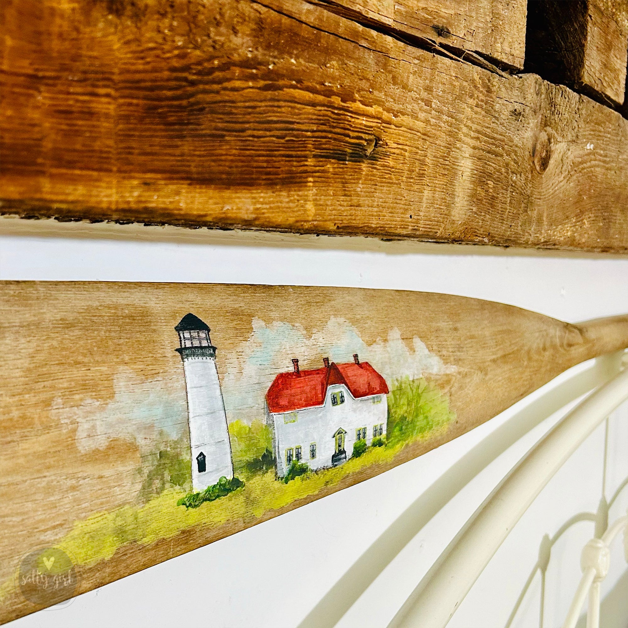 a surfboard with a picture of a lighthouse painted on it