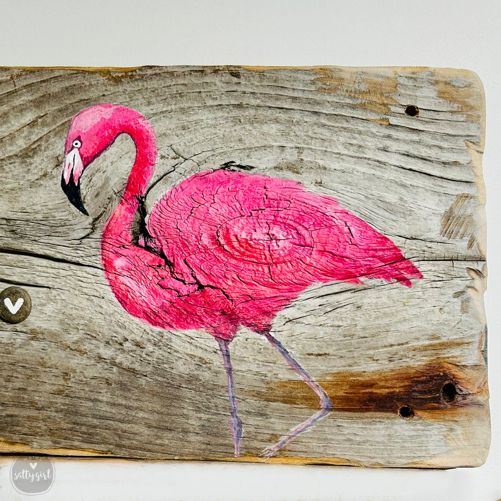 a pink flamingo painted on a piece of wood