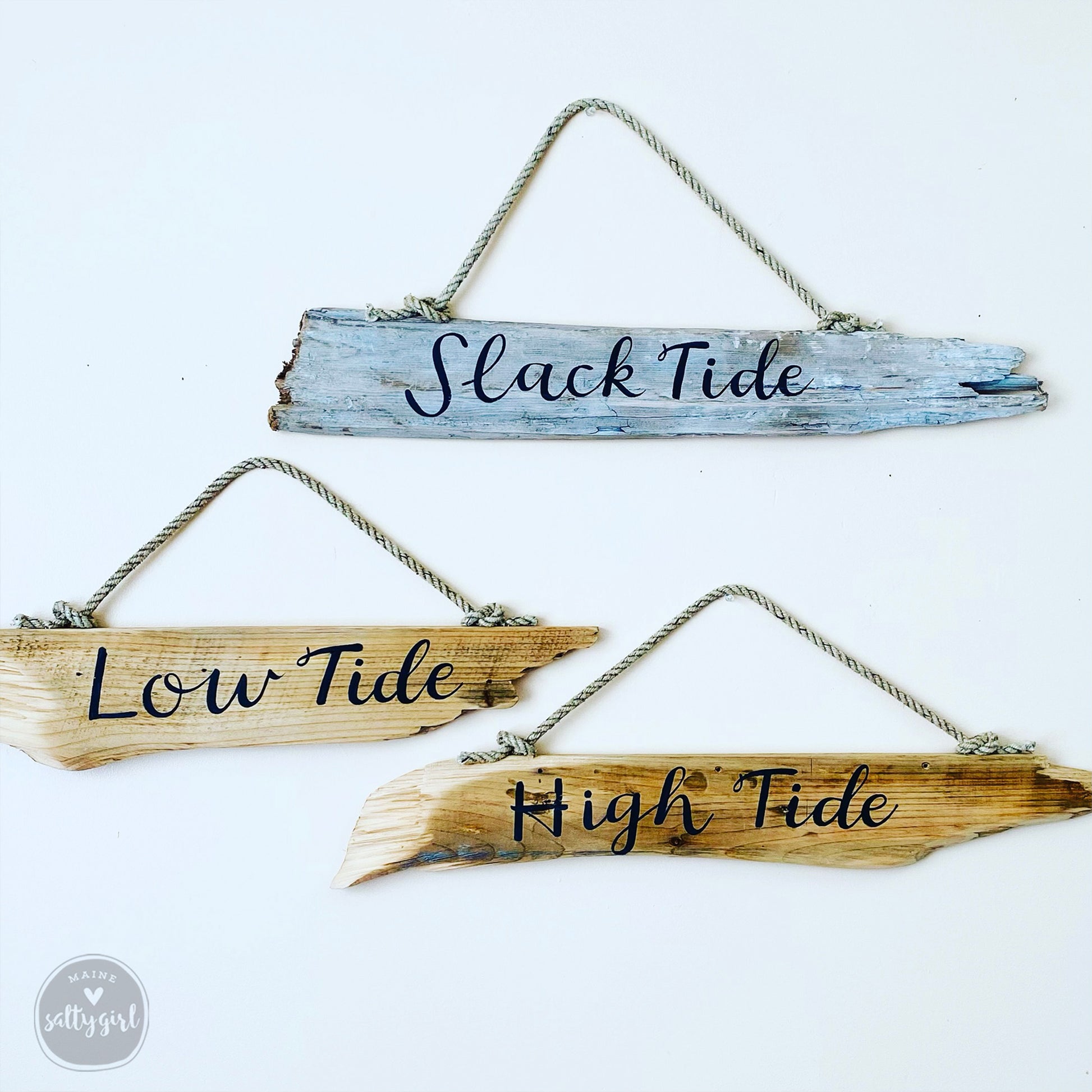 three wooden signs hanging on a white background.