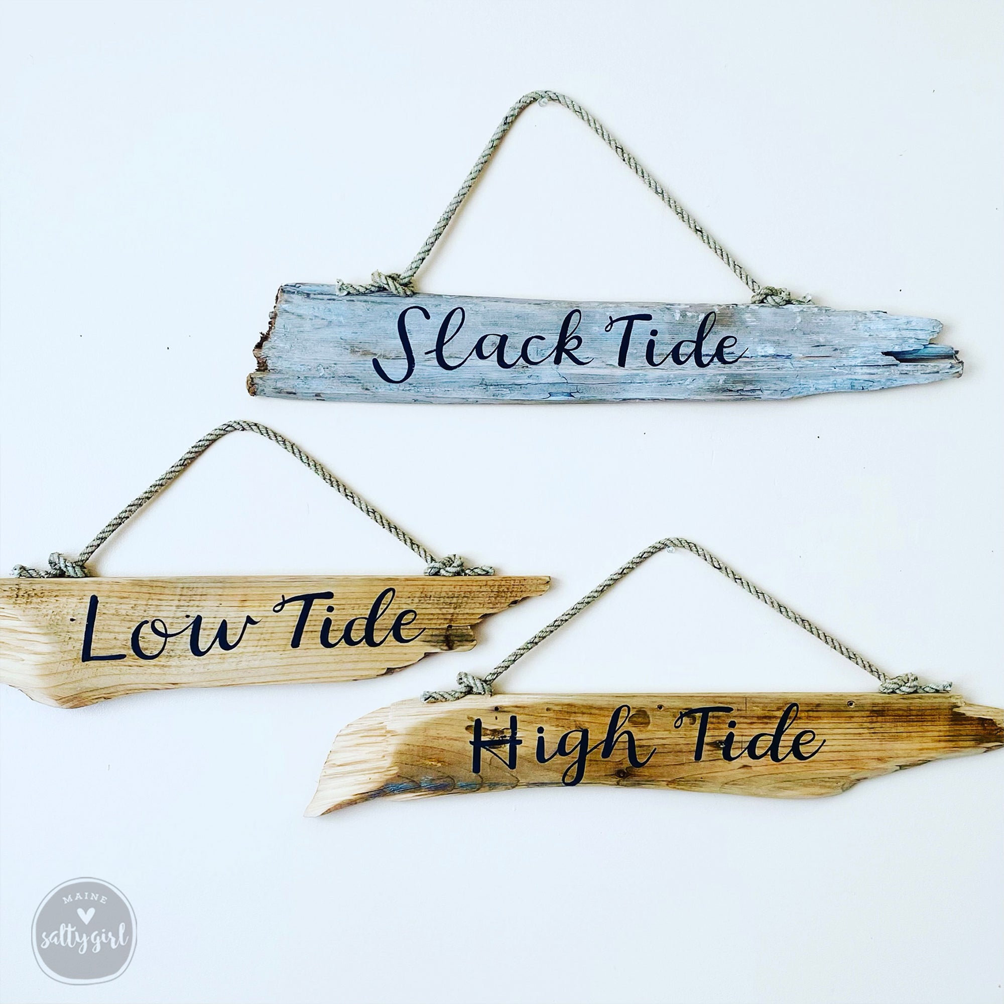 three wooden signs hanging on a white background.