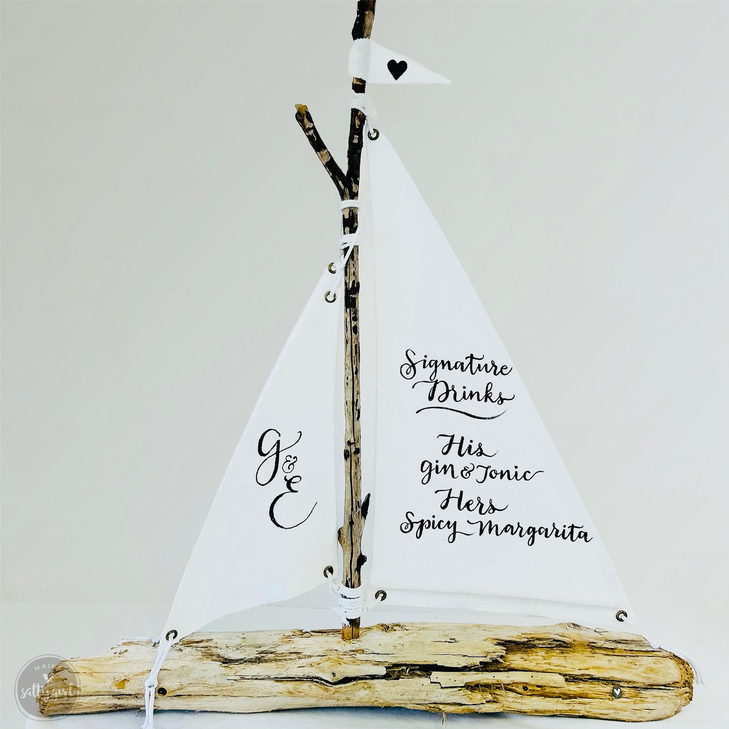 a small sail boat made out of driftwood