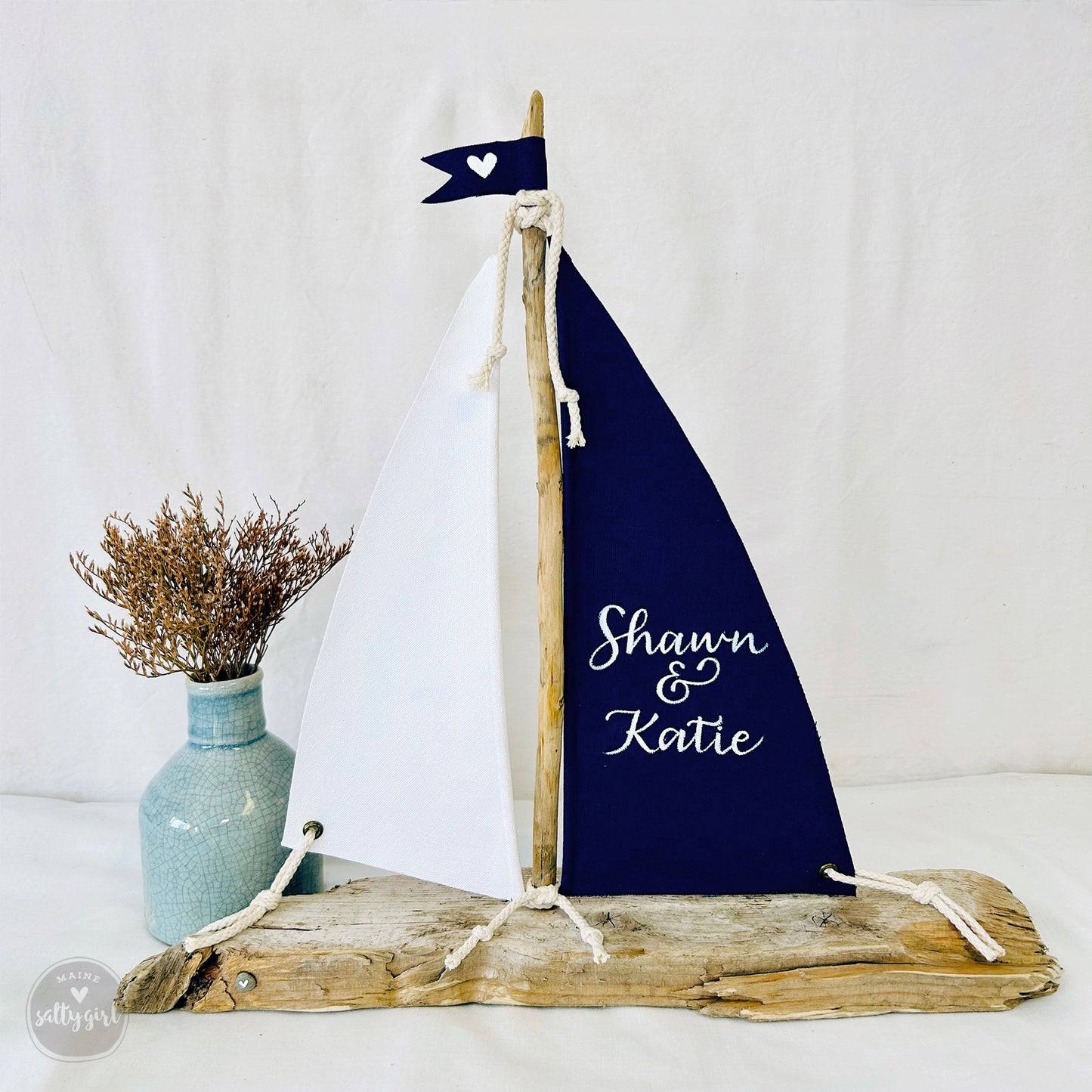 a wooden sailboat with a blue and white sail