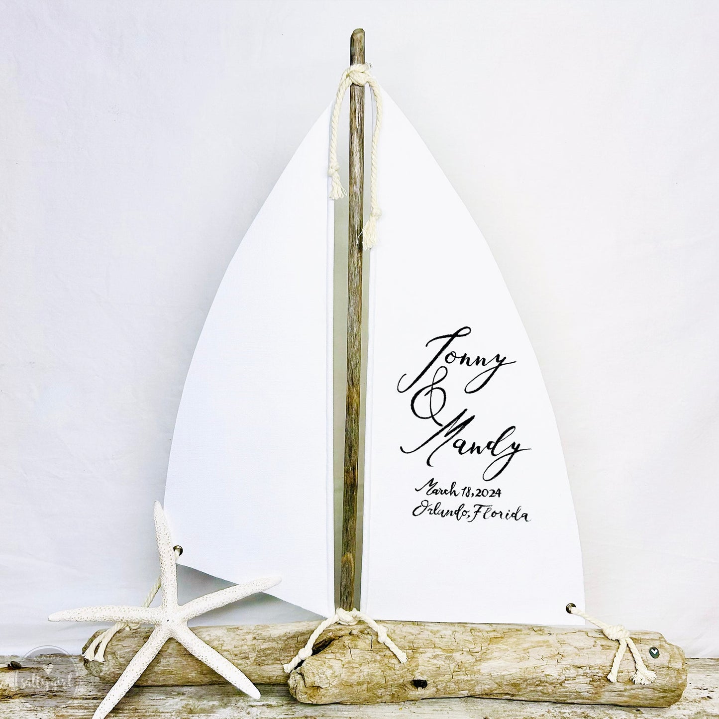 Driftwood sailboat with white sails