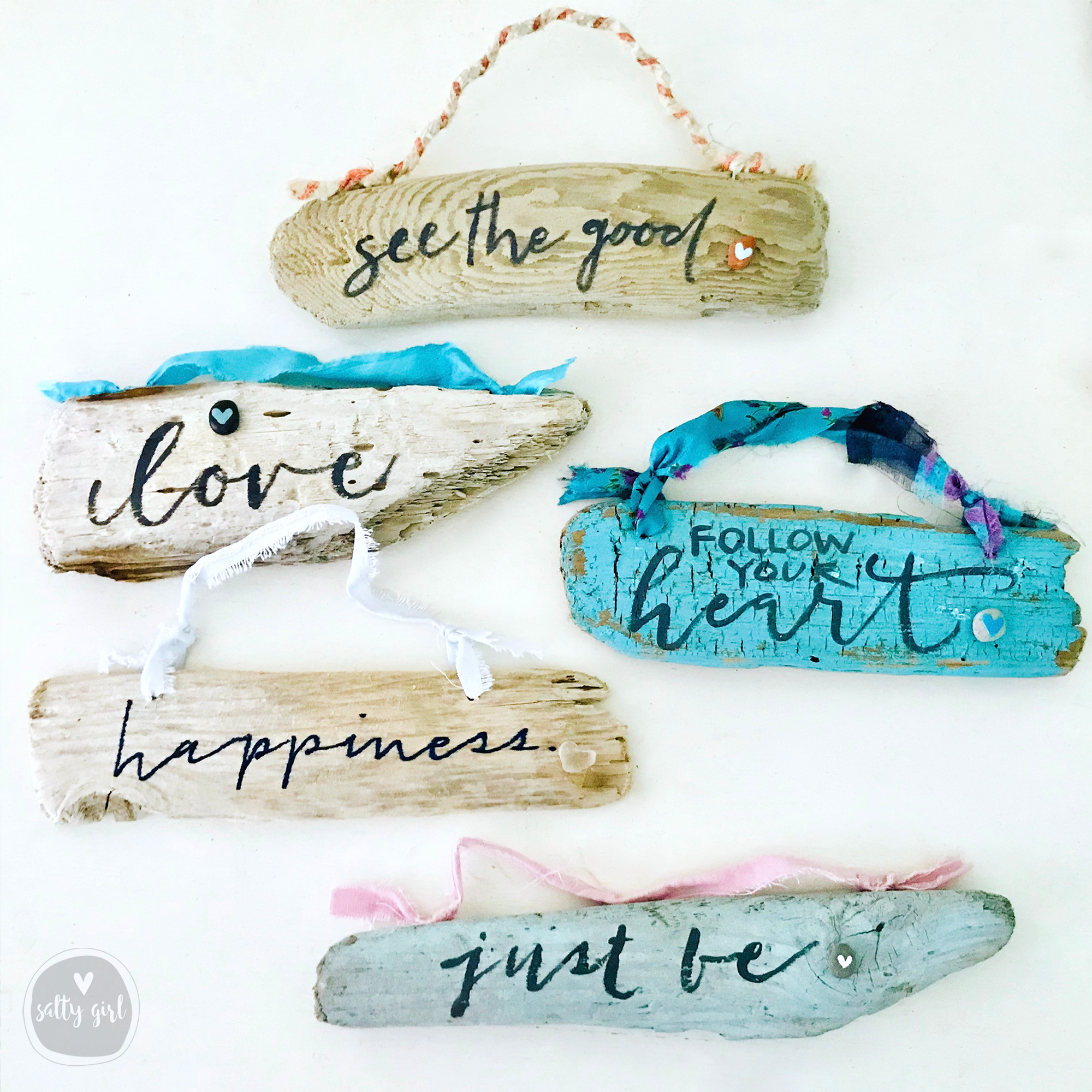 six handcrafted wooden signs with various inspirational messages, including "see the good", "love", "happiness", "follow your heart", "just be", and "just be".