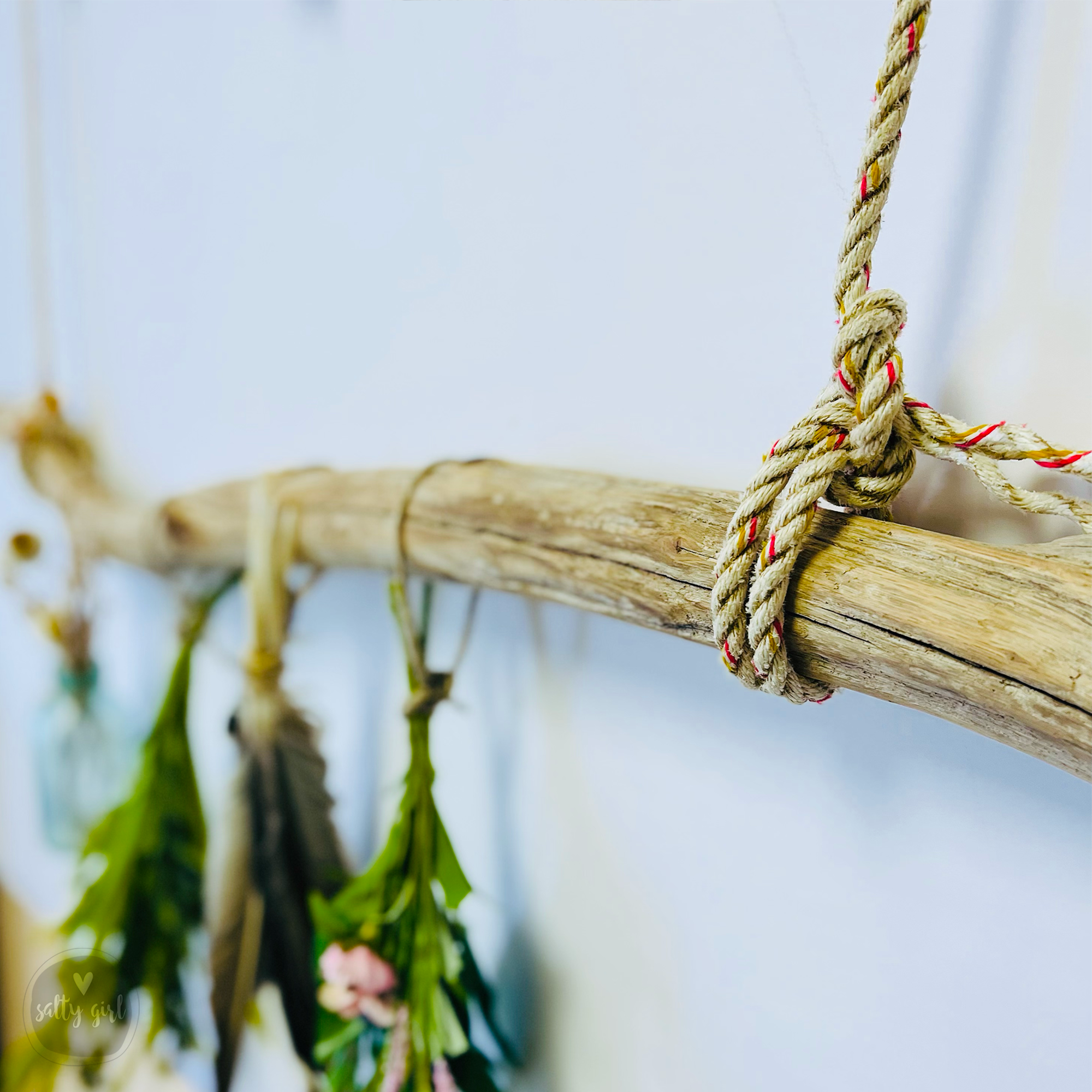 A wooden stick with a rope tied around it, hanging from a wall.