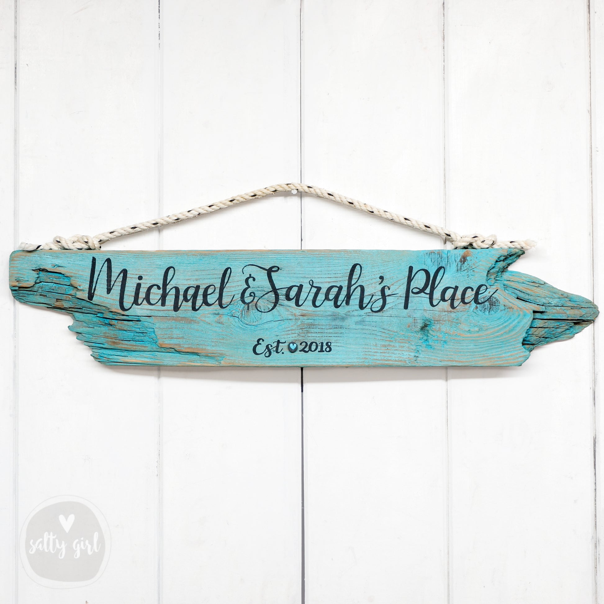 a wooden sign hanging on a white wall