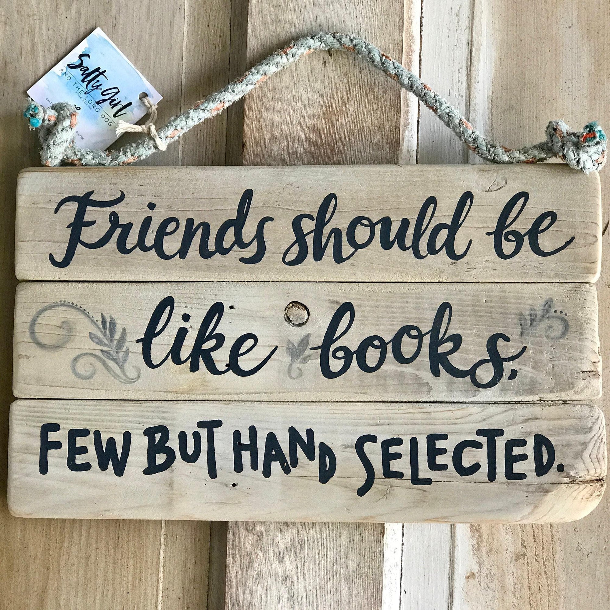 A wooden sign with the text "Friends should be like books. Few but hand selected."
