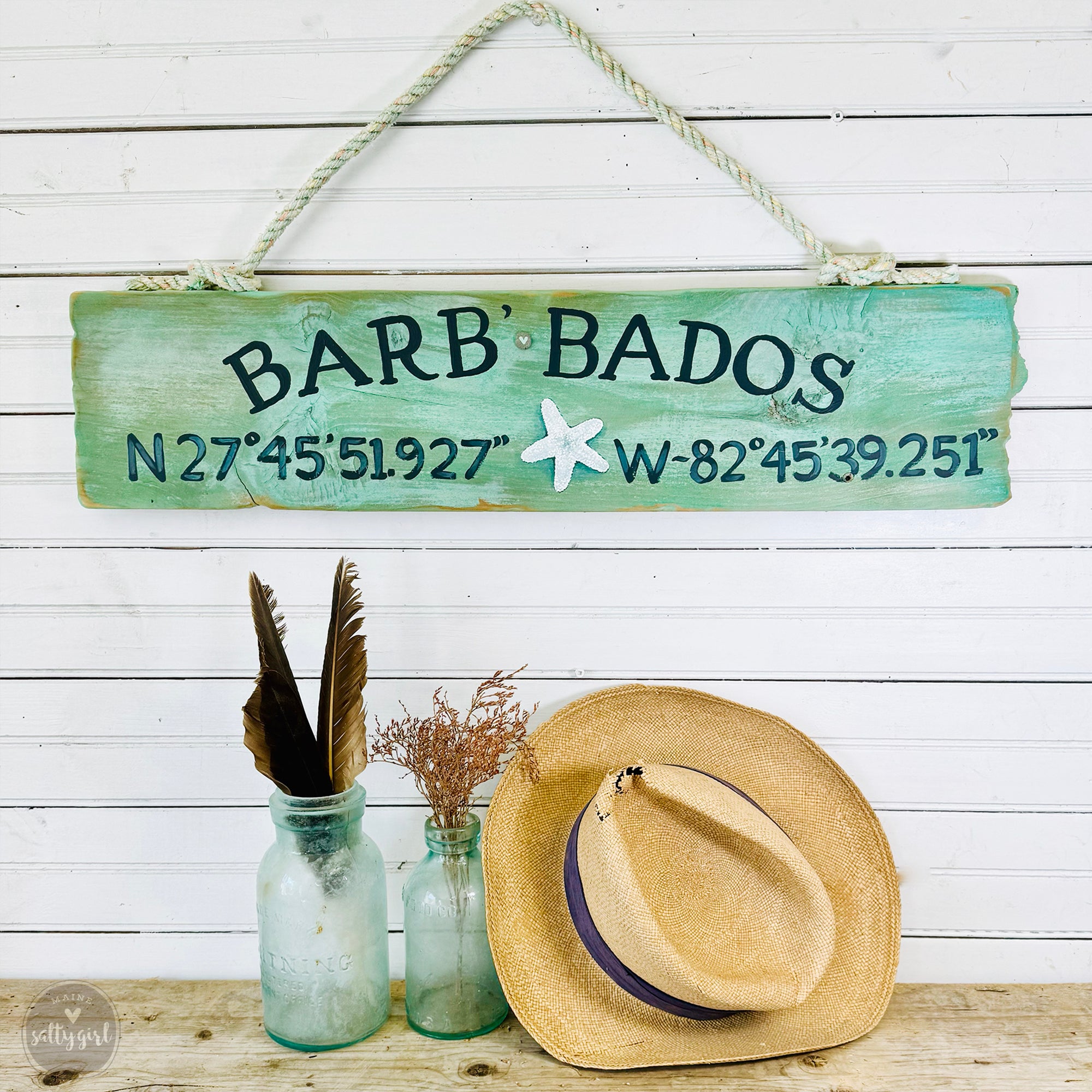 a sign that says barb'bados next to a hat and a vase