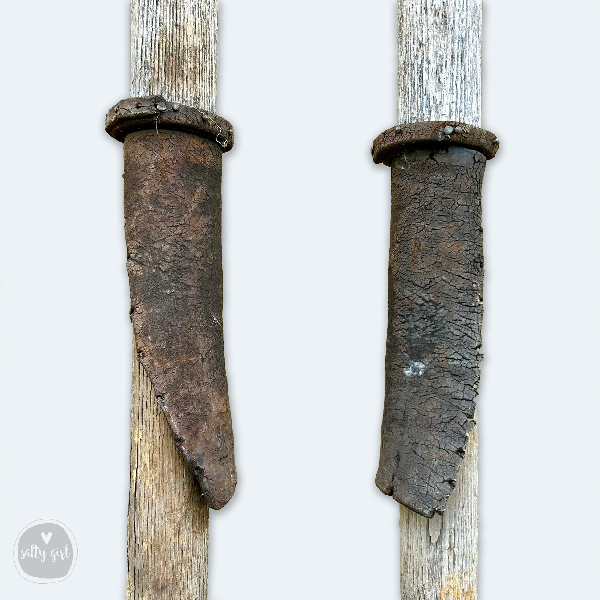 a pair of old wooden knives hanging on a wall