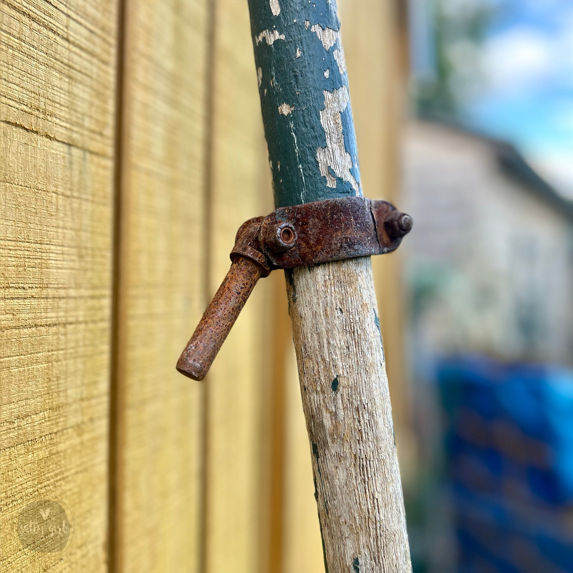 a rusted metal handle on a wooden pole