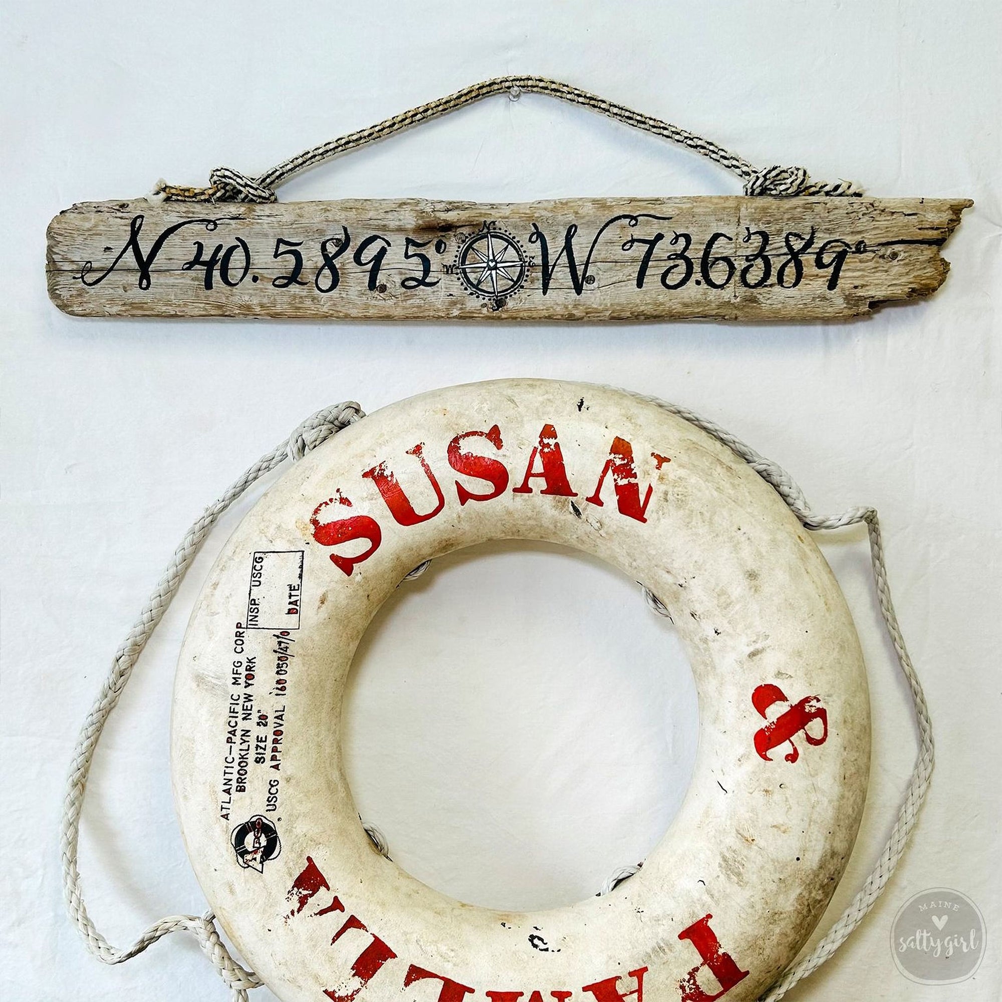 a wooden sign with a compass rose and a white life preserver with the name "SUSAN" printed on it.
