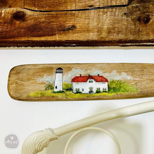 a painting of a lighthouse on a wooden board
