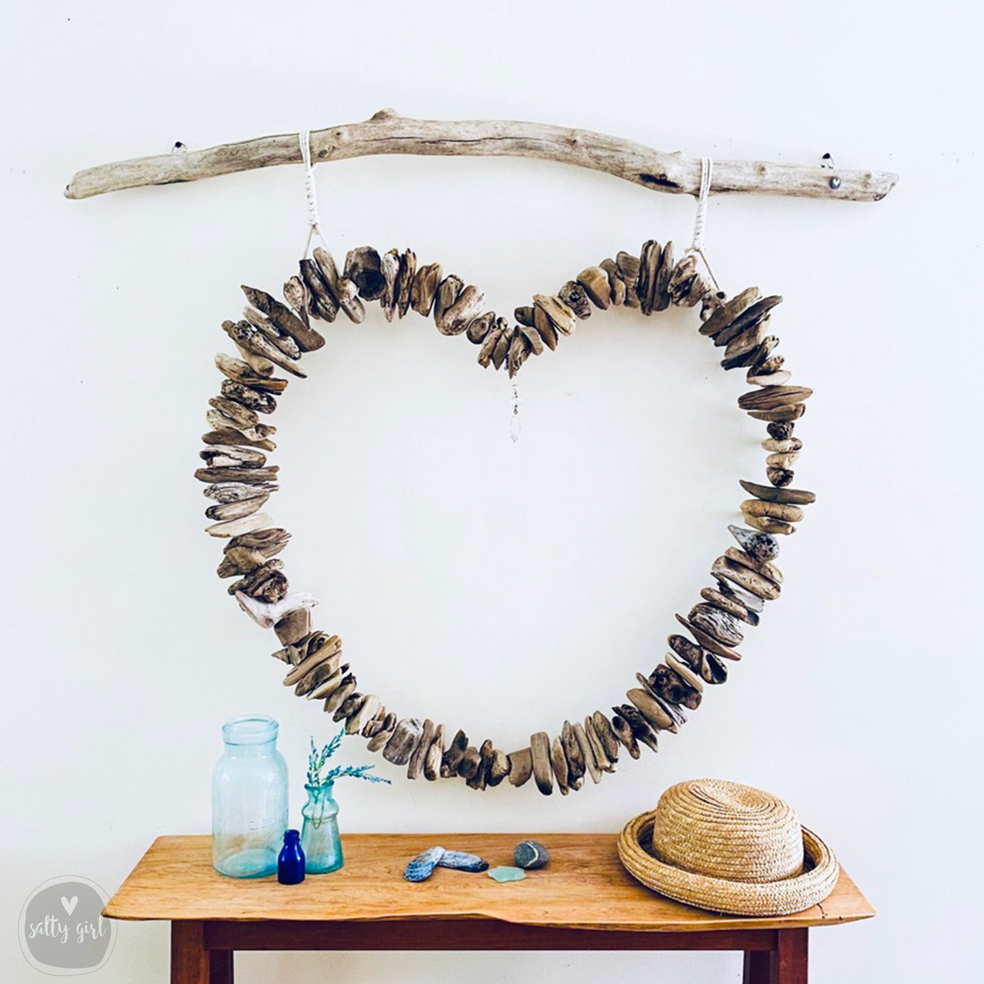 a heart made out of driftwood sitting on top of a table