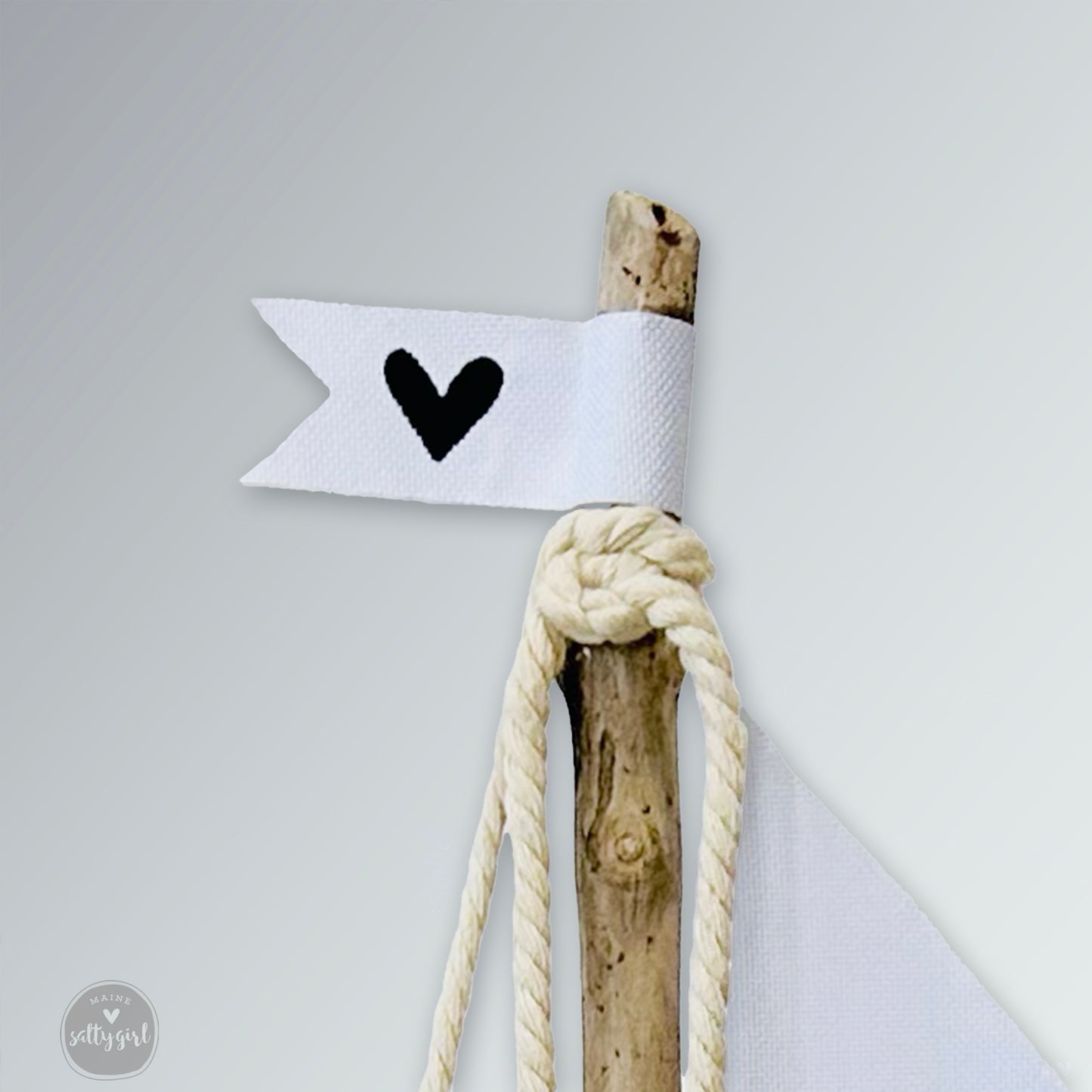 a stick with a heart on it tied to a rope