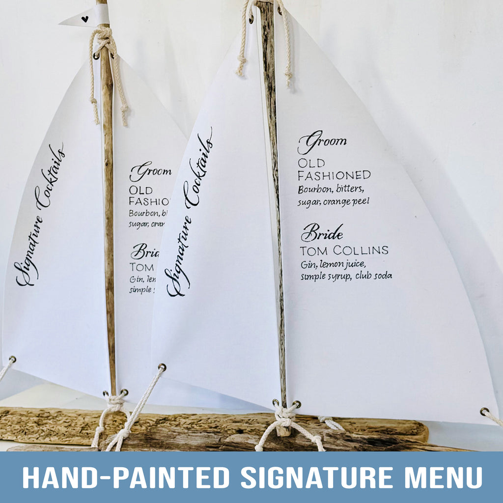 Hand-painted signature menu featuring three white sailboat-shaped menus with black text listing cocktail options and names.