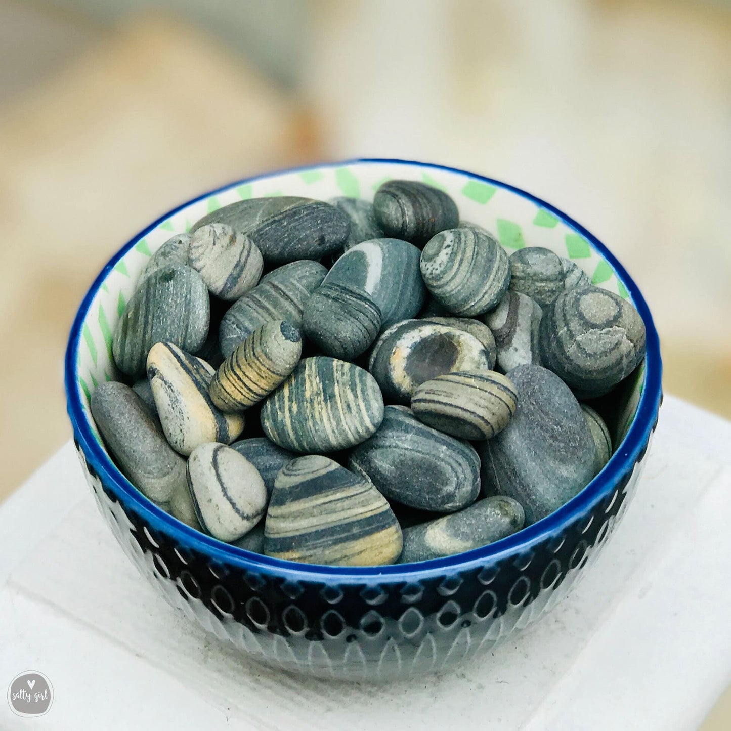 Blue dish with striped beach stones