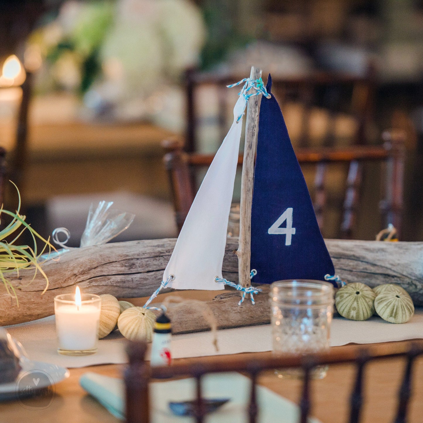 a small sailboat on a table with candles