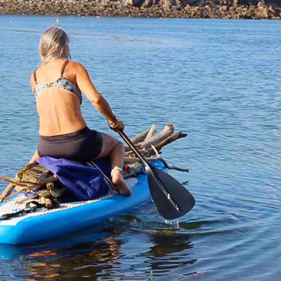 Cherie Herne on paddleboard getting driftwood