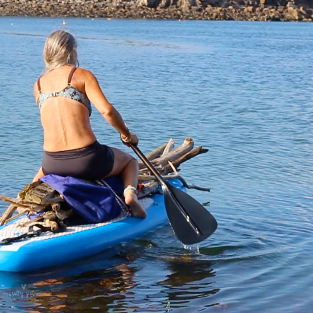 Cherie Herne on paddleboard getting driftwood