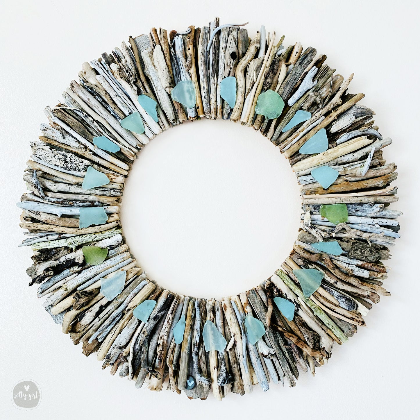 a wreath made out of old newspapers and sea glass