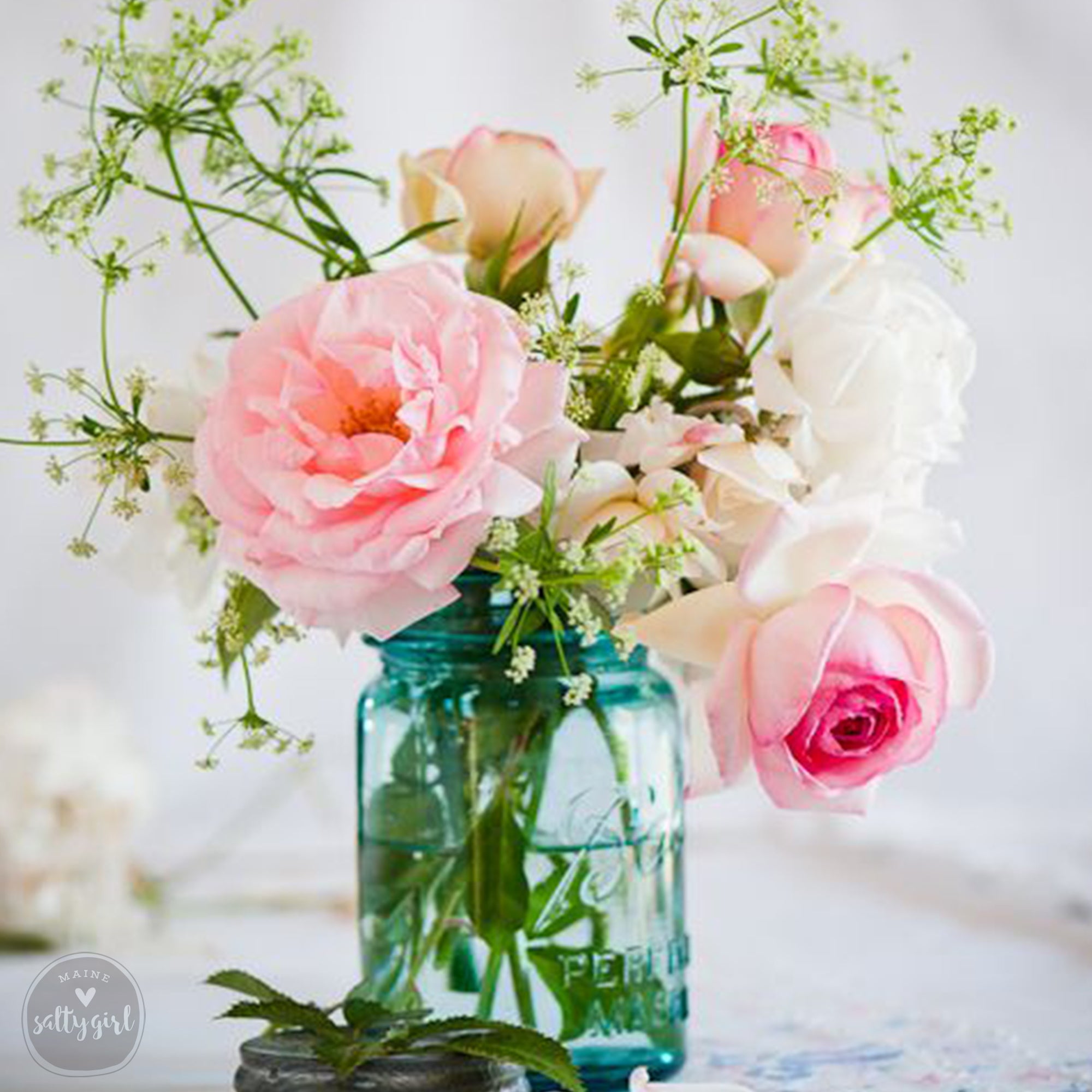 a vase filled with lots of pink and white flowers