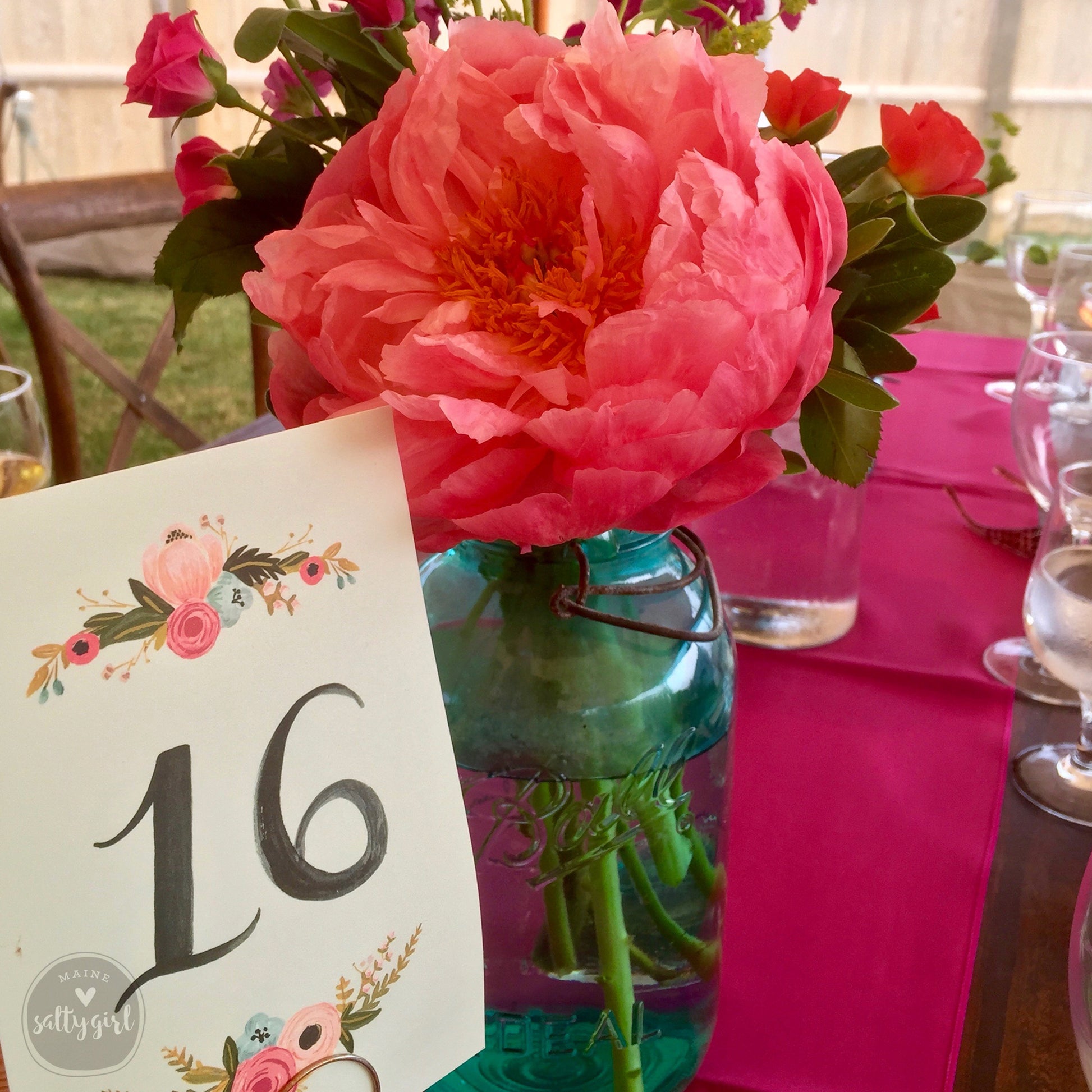 a table with a vase of flowers and a table number