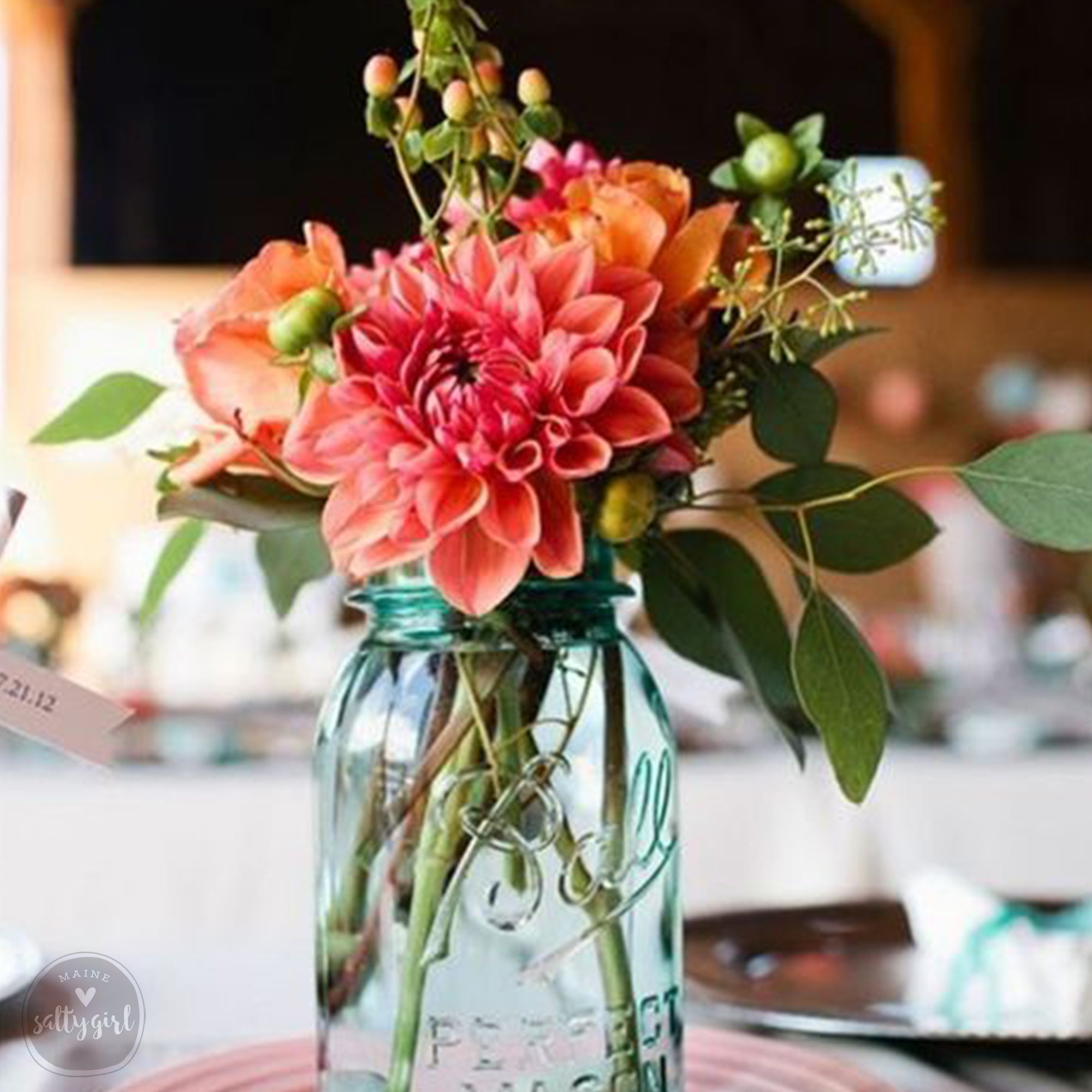 a mason jar filled with flowers on top of a table
