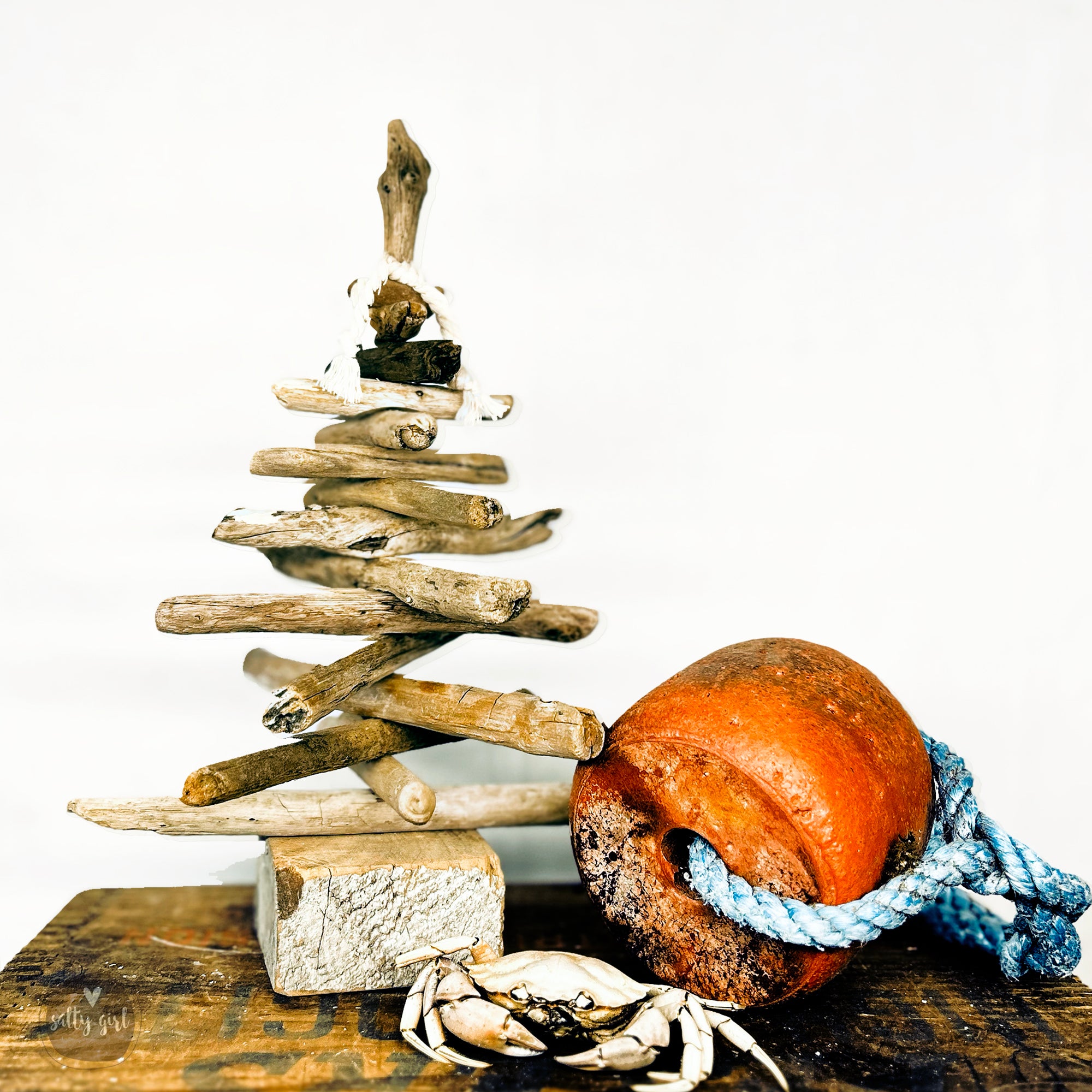 mini driftwood Christmas tree next to crab and buoy