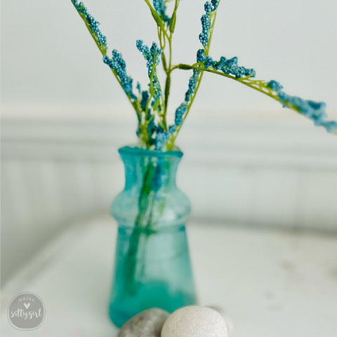 a vase filled with flowers and two eggs