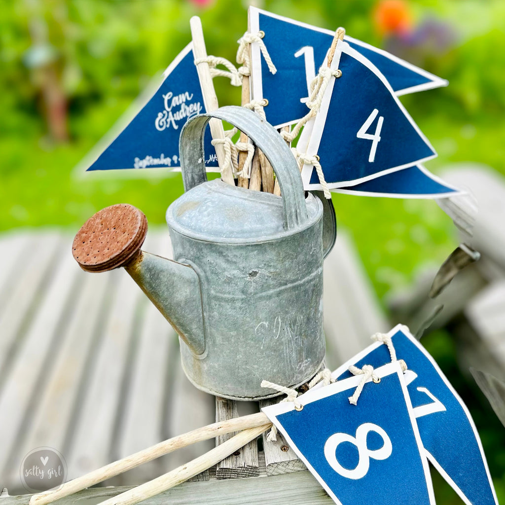 blue and white flag table numbers in metal watering can