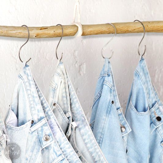 four pairs of jeans hanging on a clothes rack