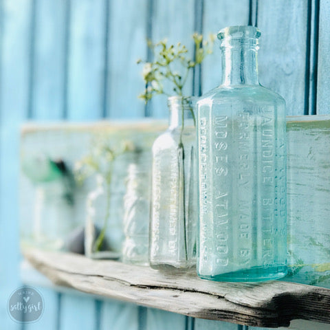 a shelf with three glass bottles on it