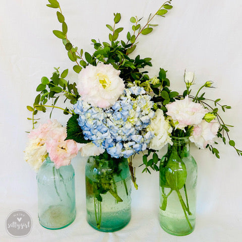 three vases filled with different types of flowers