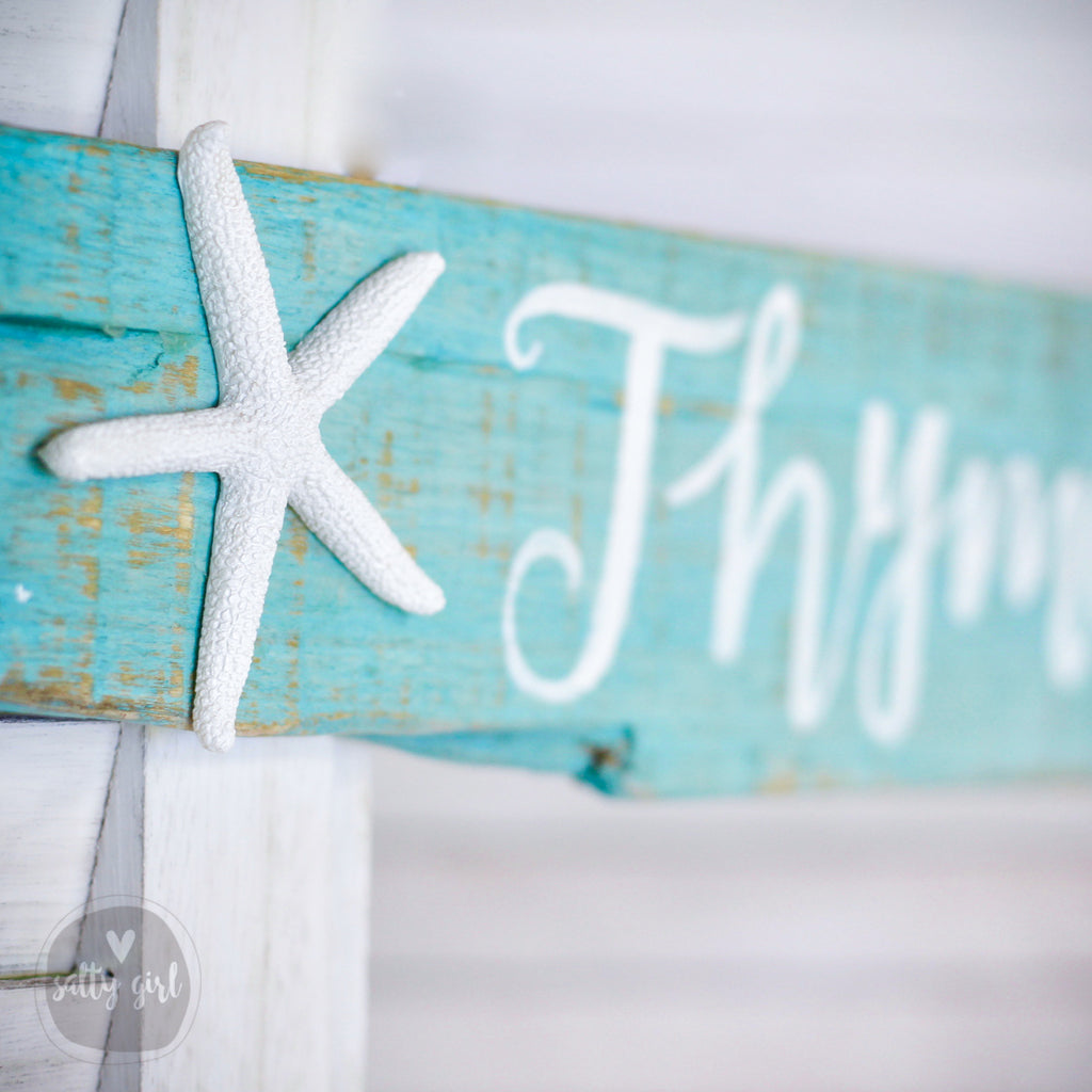 Close-up of a realistic white resin starfish accent on authentic Maine beach driftwood with hand-painted lettering.