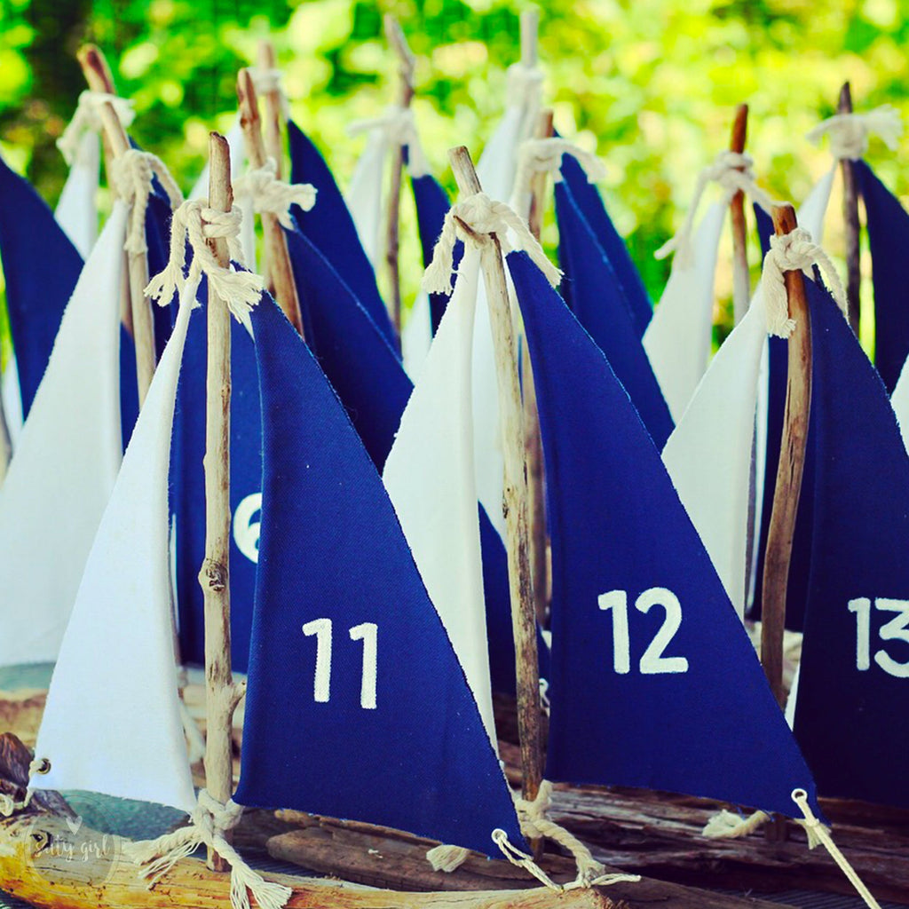 A group of blue and white sailboat-shaped decorations with the numbers 11 and 12 on them, arranged in a row.