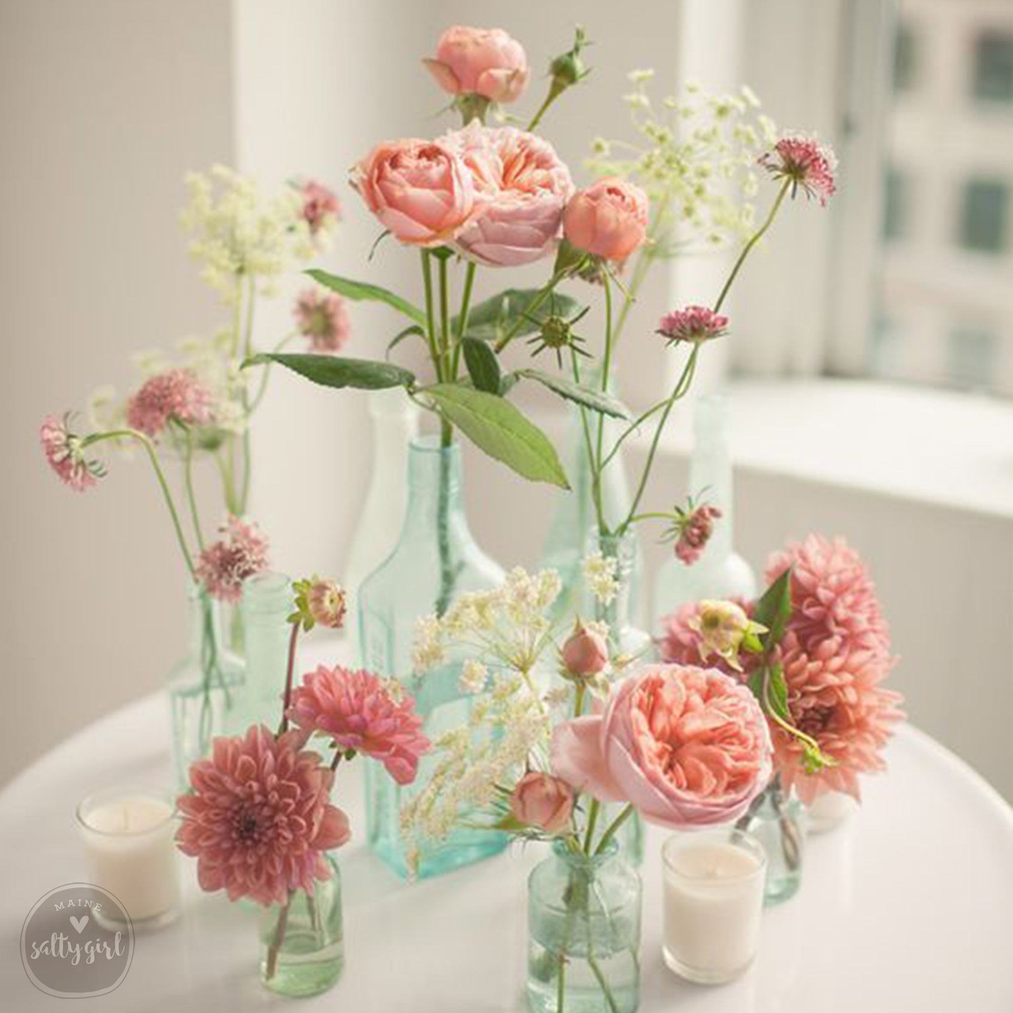 a white table topped with vases filled with flowers