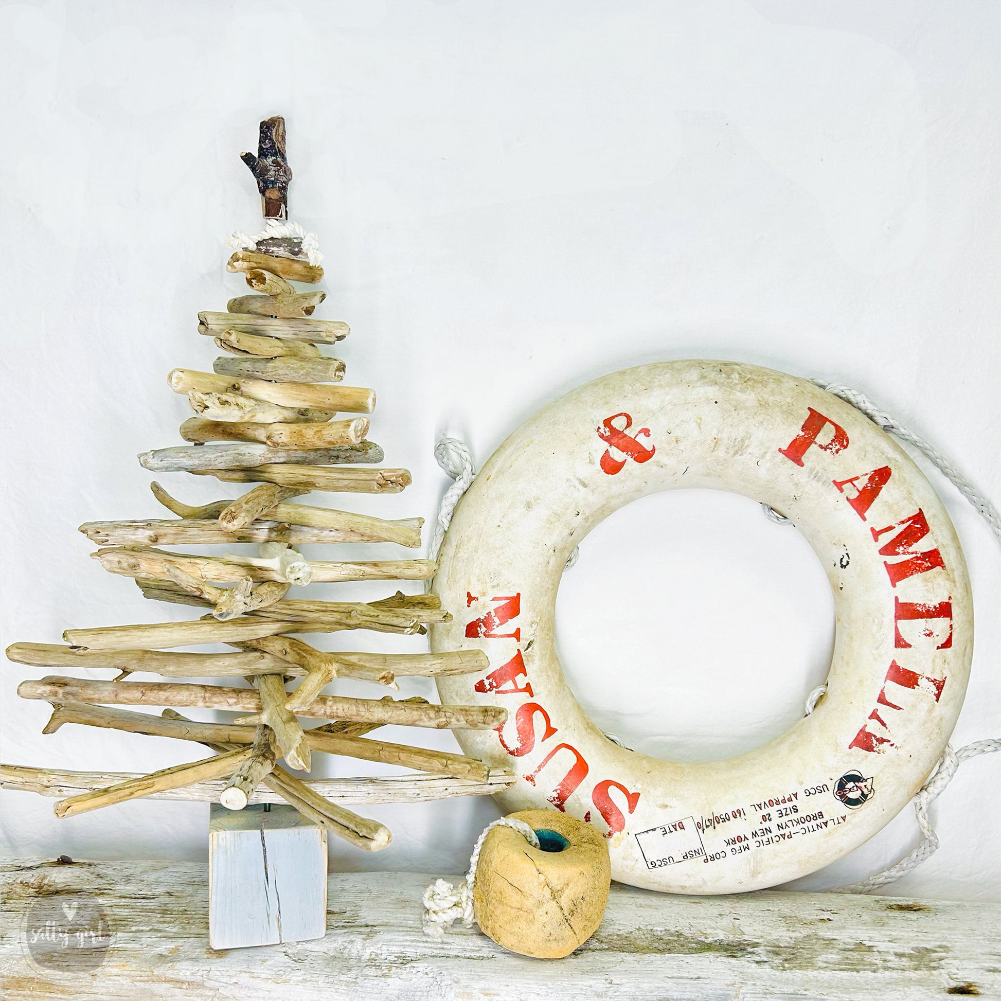 a wooden christmas tree next to a life preserver