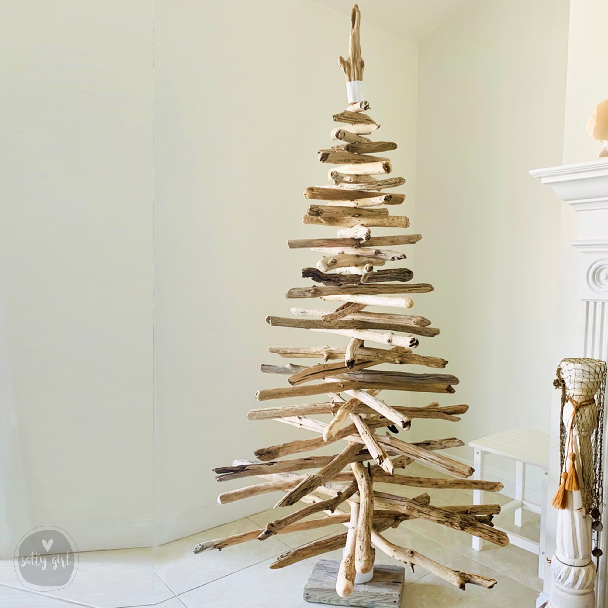 A 6 foot tall Christmas tree made of driftwood, displayed indoors against a white background.