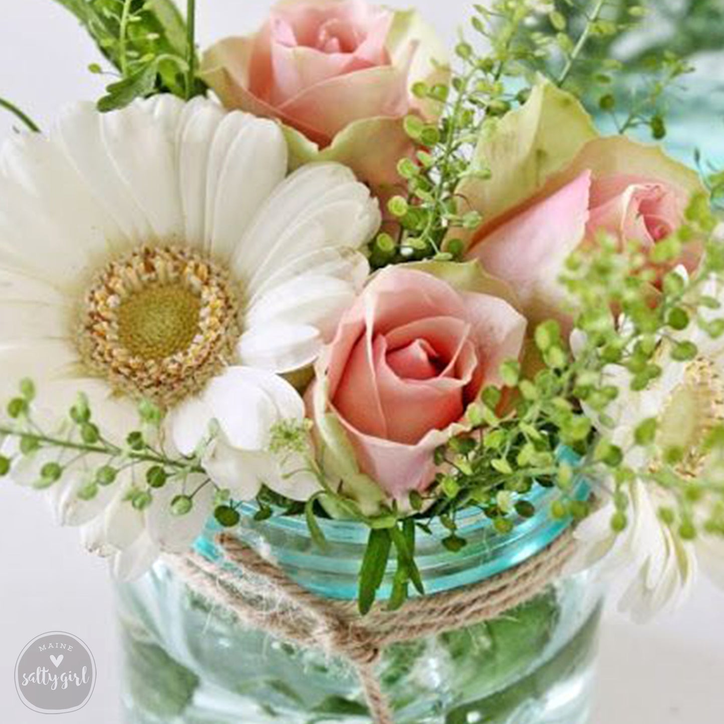 a mason jar filled with flowers on top of a table
